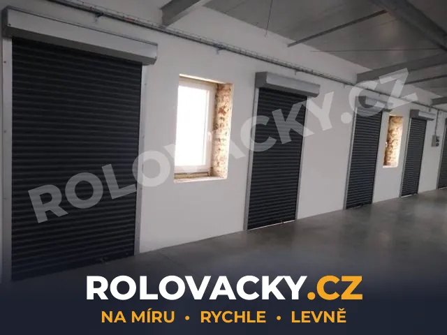 Řada černých rolovacích vrat v halovém objektu