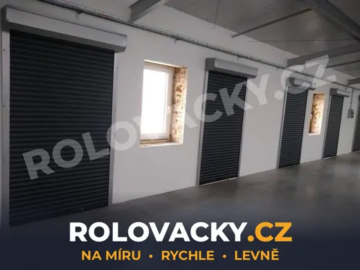 Řada černých rolovacích vrat v halovém objektu